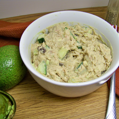 Avocado Tuna Salad in a deep white bowl with avocados barely visible to the left of the bowl