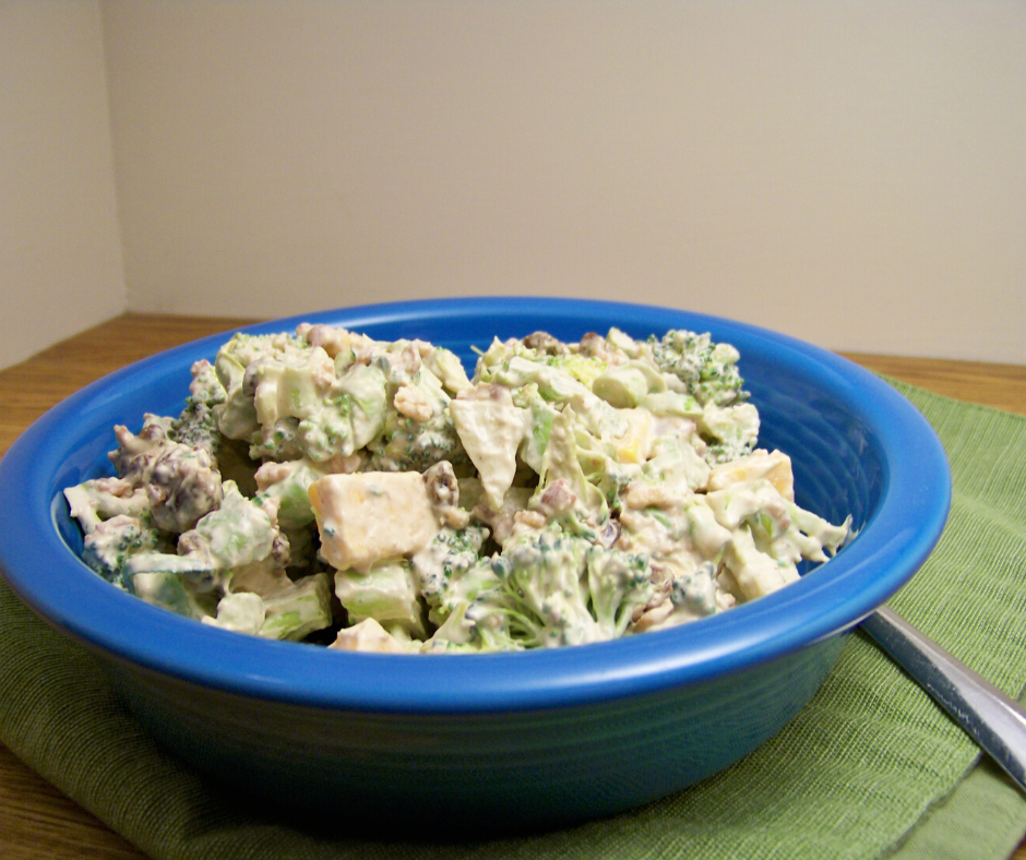 Sweet and Savory Broccoli Salad in a deep blue bowl on a green folded placemat