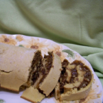 Pecan Pie Cake Roll sliced on a platter with a sage green background