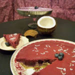 Blueberry "Cream" Pie, one version sliced in the front with an open coconut between it and a short cake stand holding the second version of the pie in a tart pan