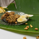Banana Nut Bread Cookies plated on a clear plate with a banana leaf underneath, walnuts around and sliced banana in the background and on the plate