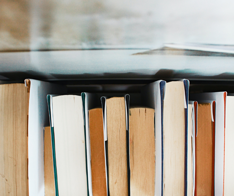 Looking down from the top on closed books that are lined up as if on a shelf