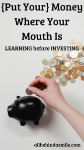 Light background with a black piggy bank and white hand putting various coins into the bank with the text [Put Your] Money Where Your Mouth Is Learning before Investing