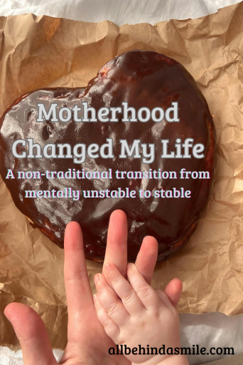 Picture of two hands over a heart shaped cake with the text motherhood changed my life: a non-traditional transition from mentally unstable to stable