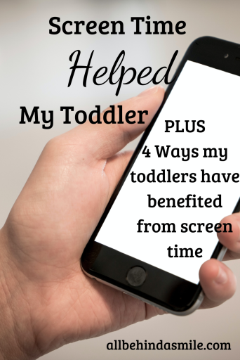 Image of a hand holding a cell phone with a white screen and the text screen time helped my toddler plus 4 ways my toddlers have benefited from screen time