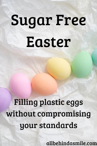 Pastel dyed Easter eggs on a crumpled white paper background with text: Sugar Free Easter Filling plastic eggs without compromising your standards
